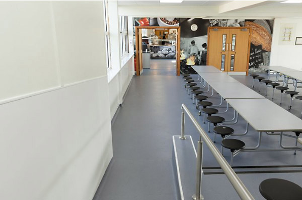 A photo looking down a refurbished student dining hall from the entrance way