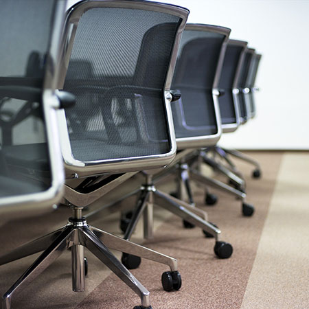 Photo showing the backs of modern office chairs in chrome and black