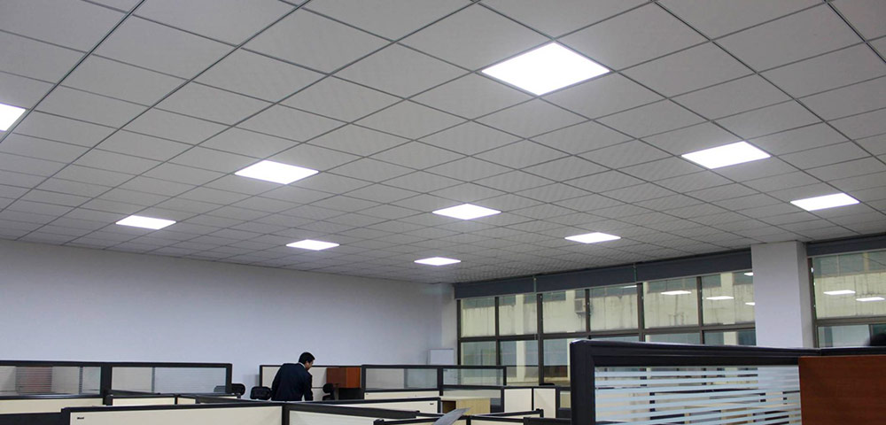 A photo of a large open plan office with modern lights and suspended ceiling